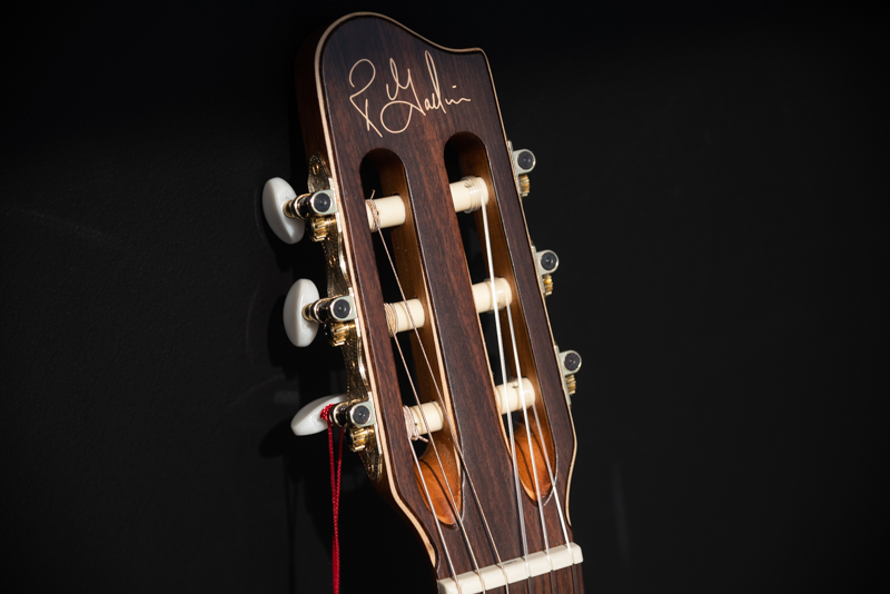 Close-up of the headstock of a Godin Presentation classical guitar with a dark stain finish and chrome tuning machines.